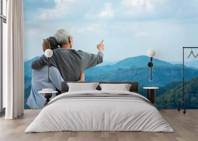 Asian Lifestyle senior couple hug and pointing the mountain nature.  Old people happy in love romantic and relax time.Â  Tourism family elderly retirement travel in summer leisure and destination. Wall mural